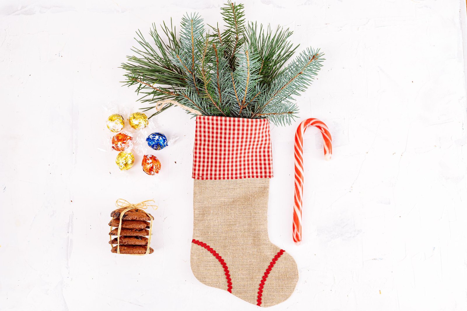 Stocking stuffers for men spilling out of a Christmas stocking with small wrapped gifts