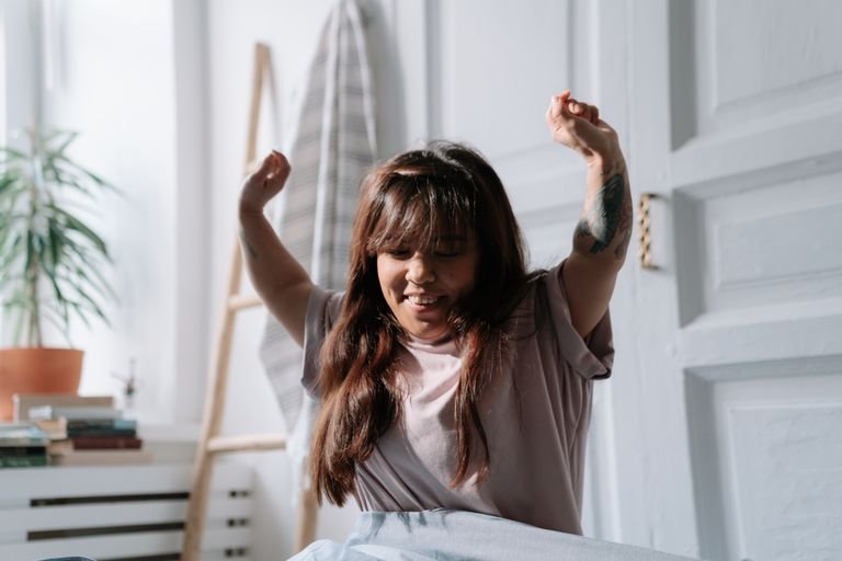 Woman waking up with fresh skin after learning how to make your skin glow overnight