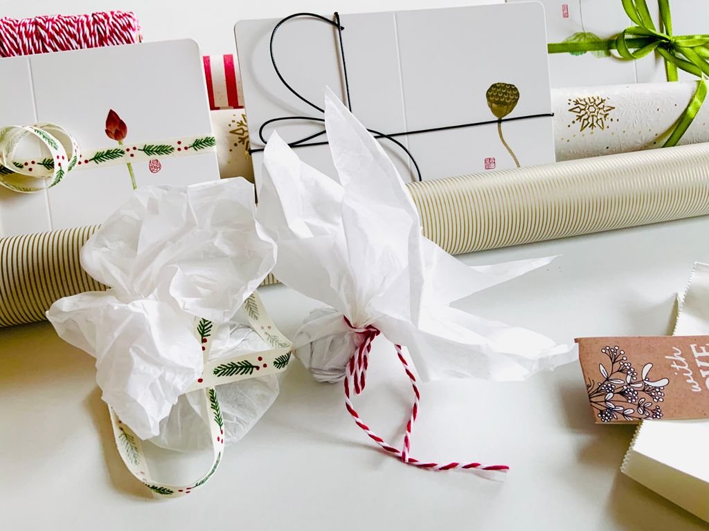 Wrapping small gifts with tissue and ribbon to fill a stocking for him